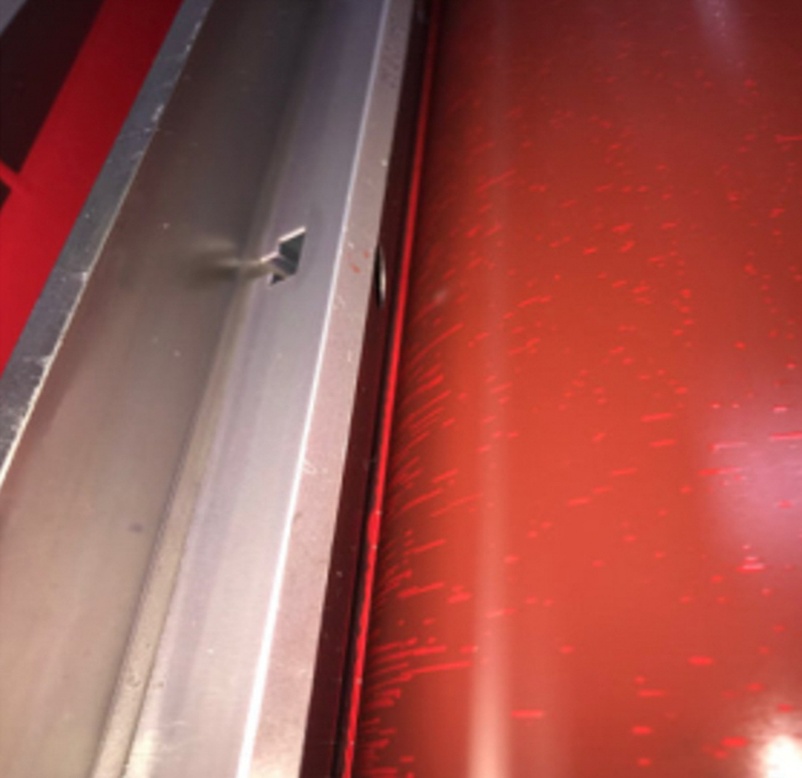 Ink spitting caused by ink build-up on the outside of the metering blade